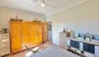 Schlafzimmer der Finca bei Algaida mit Holzschrank, Deckenventilator und Terrakottaboden