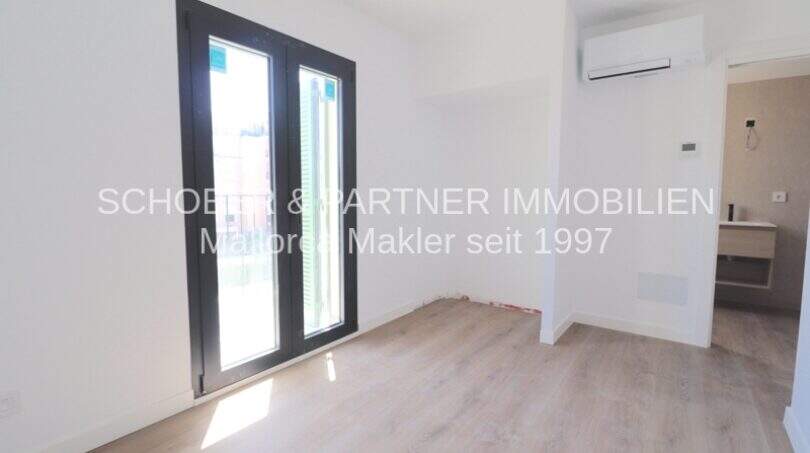 Dormitorio claro con suelo de parqué, aire acondicionado y acceso a terraza en apartamento de nueva construcción, Cala Millor