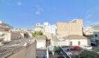 View from the balcony onto roofs and neighboring buildings in Ses Cadenes, Palma de Mallorca, blue sky