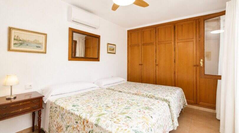 Helles Schlafzimmer der Finca Mallorca mit Doppelbett, Holzschrank, Deckenventilator und Klimaanlage