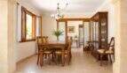 Elegantes Esszimmer der Mallorca-Finca mit Holztisch, Vitrine und Natursteinboden
