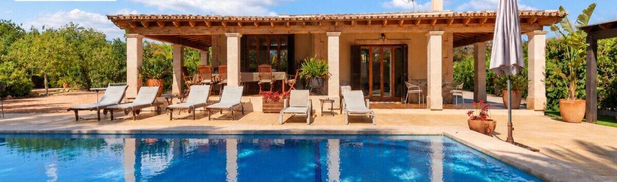Finca Palma de Mallorca: Großer Außenpool mit Liegestühlen und überdachter Terrasse mit Steinpfeilern.