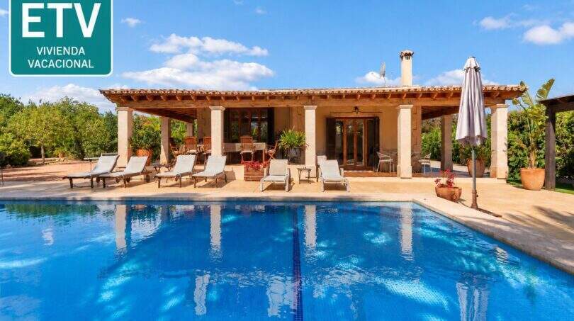 Finca Palma de Mallorca: Großer Außenpool mit Liegestühlen und überdachter Terrasse mit Steinpfeilern.
