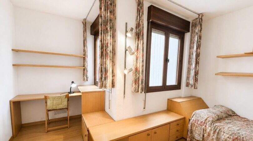 Helles Schlafzimmer mit Einzelbett, Schreibtisch, Einbauschränken und Fenster in Wohnung am Paseo Marítimo, Palma