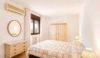 Helles Schlafzimmer mit Doppelbett, Vintage-Holzmöbeln, Klimaanlage und Fenster in Palma-Wohnung