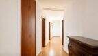 Heller Flur mit Holztüren, Parkettboden und klassischer Kommode in exklusiver Wohnung am Paseo Marítimo, Palma.