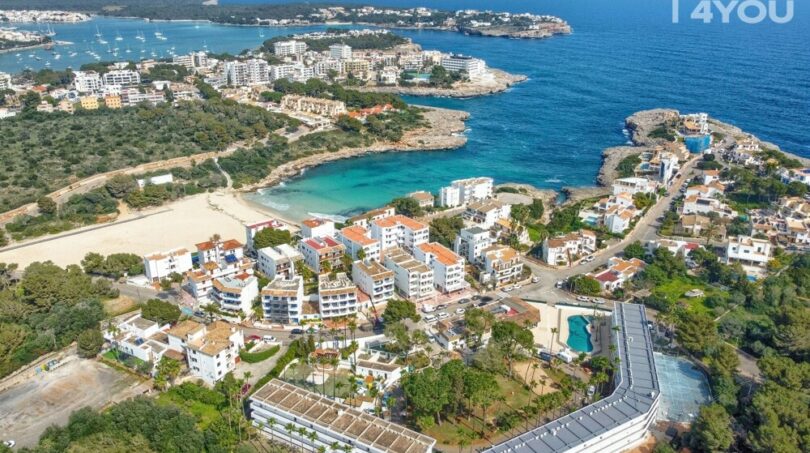 Vista aérea del apartahotel Portocolom, vista al mar, bahía turquesa, piscina, arquitectura mediterránea