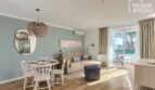 Sala-comedor luminosa con balcón, aire acondicionado, suelo de madera e interior moderno en el apartahotel Portocolom