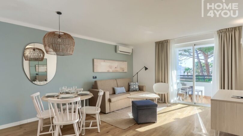 Sala-comedor luminosa con balcón, aire acondicionado, suelo de madera e interior moderno en el apartahotel Portocolom