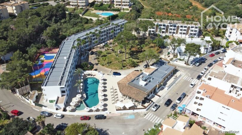 Vista aérea del apartahotel Portocolom: complejo moderno con piscina, palmeras, restaurante e instalaciones recreativas en ambiente mediterráneo.