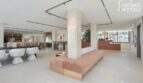 Área de lobby moderna del apartahotel en Portocolom con recepción, área de lounge y diseño elegante.