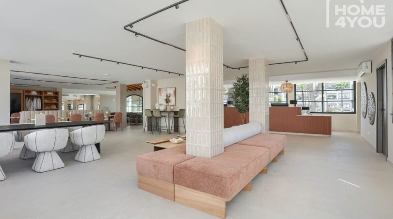 Área de lobby moderna del apartahotel en Portocolom con recepción, área de lounge y diseño elegante.