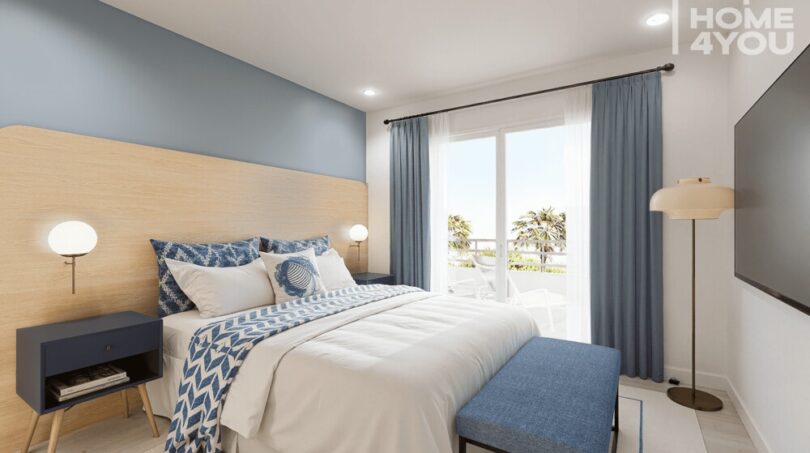 Dormitorio luminoso en el apartahotel Portocolom, acentos azules, cabecero de madera, balcón con vista a palmeras, 63 m²