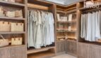 Elegante vestidor con estantes de madera, iluminación y almacenamiento en el apartahotel Portocolom.