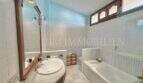 Helles Badezimmer mit Badewanne, Waschtisch und blauer Decke im Ferienhaus in Muro, Mallorca.
