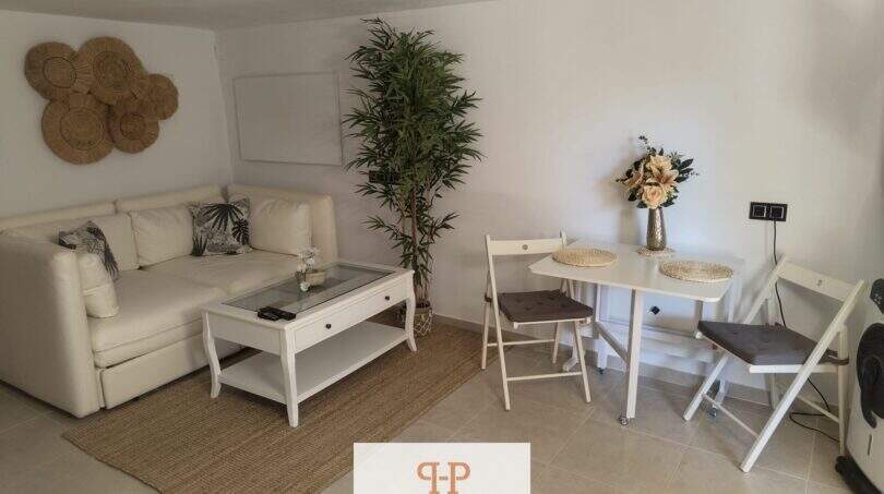 Helles Wohnzimmer mit weißem Sofa, Glascouchtisch und Essbereich im Ferienhaus nahe Strand Porto Cristo Novo