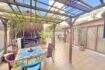 Überdachte Terrasse mit Holzpergola, Esstisch, Pflanzen und Loungebereich der Wohnung in Palma-City.