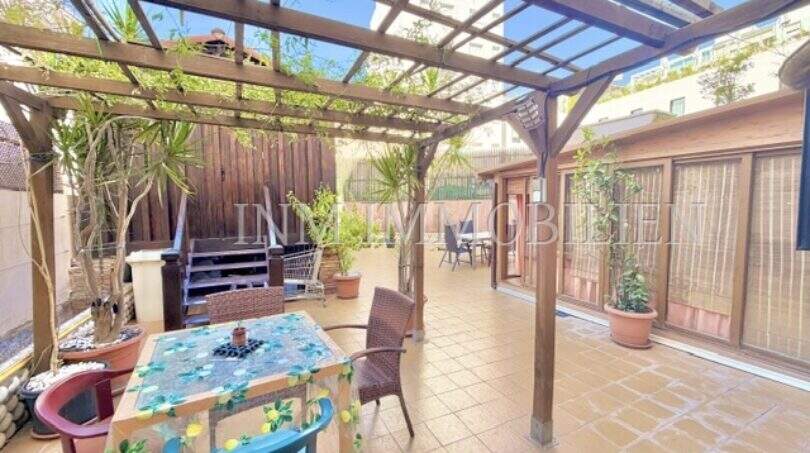 Überdachte Terrasse mit Holzpergola, Esstisch, Pflanzen und Loungebereich der Wohnung in Palma-City.