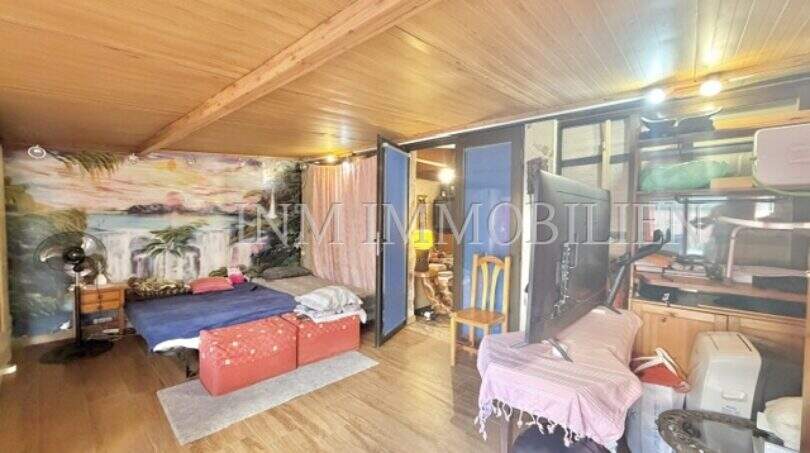 Gemütliches Schlafzimmer mit Holzdecke, Wandgemälde und Parkettboden in Palma-City-Wohnung