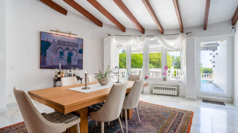 Helles Esszimmer mit Holzbalkendecke, großem Esstisch und Meerblick-Fenstern in Villa Cala Murada