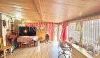 Wohnzimmer mit Holzdecke, Laminatboden, TV-Bereich und Schreibtisch mit Blick zur Terrasse