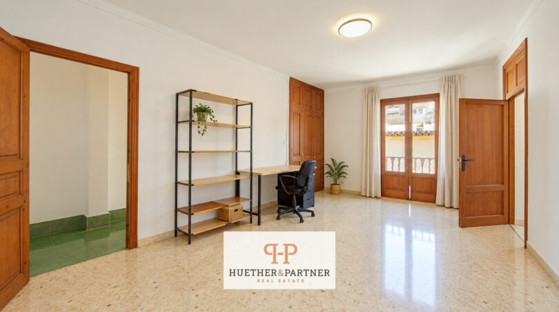 Helles Arbeitszimmer mit Terrakottaboden, Holztüren, Balkonzugang und Schreibtisch im Stadthaus Manacor