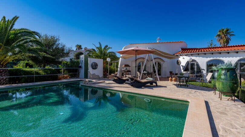 Outdoor area of the sea view villa in Cala Murada with turquoise pool, sun loungers and Mediterranean garden ambience