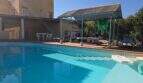 Outdoor pool of the finca in Cala Millor with terrace, pergola and Mediterranean residential building in the background