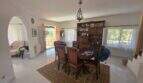 Bright dining room of the finca with antique wooden table, arched passage and terrace door to the garden.