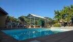 Cala Millor finca: Blue pool with gazebo, sun loungers and lush greenery under sunny sky.