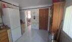 Kitchen of the finca in Cala Millor with tiled floor, refrigerator, wooden door and wall tile decor