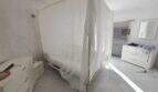Bright bedroom of the finca in Cala Millor with four-poster bed, white dressers and tile floor