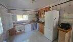 Rustic kitchen of the finca in Cala Millor with wooden cabinets, tiles and white built-in appliances