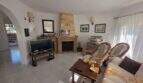 Bright living room of the finca in Cala Millor with fireplace, rattan chairs and sofa
