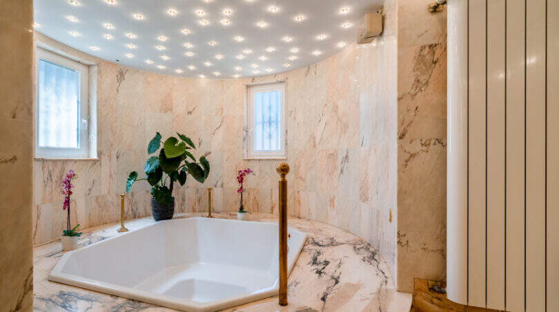 Luxuriöses Marmorbad mit achteckiger Einbau-Badewanne, Messingarmaturen und Sternenhimmel-Beleuchtung in Poolvilla Cala Murada