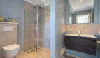 Modern bathroom of the sea view villa in Cala Murada with glass shower, wall toilet and elegant washbasin.