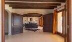 Elegant entrance area of Felanitx finca with wooden beam ceiling, round arches and dark mahogany doors