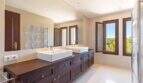Exclusive bathroom of Felanitx finca with double sink, dark wooden base cabinet and large wall mirror