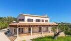 Exclusive finca in Felanitx: Two-story Mediterranean villa with columned veranda, terracotta roof and olive tree in greenery.