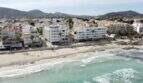 Luftaufnahme Strandpromenade Cala Millor, weiße Gebäude in erster Meereslinie, türkisfarbenes Meer, Bergpanorama