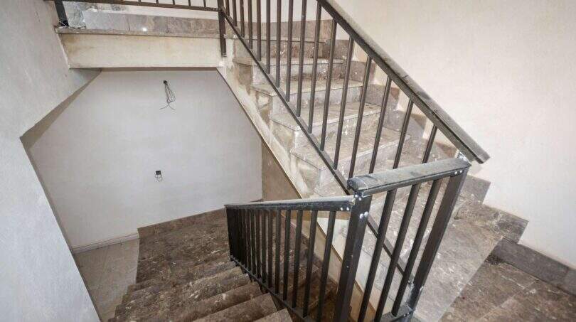 Treppenhaus mit Marmortreppe und schmiedeeisernem Geländer in Investmentimmobilie erster Meereslinie, Cala Millor