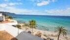 Balkon mit Panoramablick auf türkisblaues Meer, Sandstrand und Palmen in erster Meereslinie Cala Millor