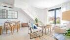 Salón luminoso de la villa nueva en Cala Romántica con escalera, muebles modernos y ventanales panorámicos