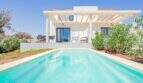 Villa nueva Cala Romántica: Casa de vacaciones blanca con pérgola, piscina privada y jardín mediterráneo en Porto Cristo Novo.