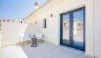 Azotea soleada de la villa nueva en Cala Romántica con muebles lounge y puertas correderas de vidrio modernas.