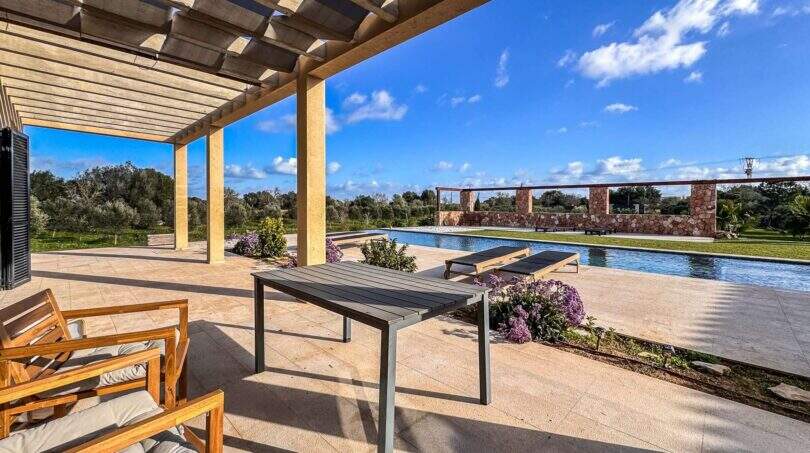 Sonnige Terrasse mit Pergola, Loungemöbeln und Pool der Luxusfinca in Ses Salines