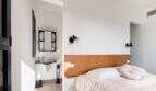 Helles Schlafzimmer mit Holzkopfteil, rosa Kissen und angrenzendem Badbereich in mediterraner Luxusfinca Ses Salines