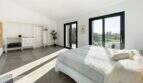 Helles Schlafzimmer der Luxusfinca in Ses Salines mit Terrassenzugang, offenem Kleiderschrank und Gartenblick.