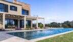 Luxusfinca Ses Salines: Infinity-Pool mit Pergola, Sonnenliegen und mediterranem Garten bei strahlendem Himmel.