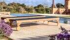 Poolterrasse der Luxusfinca mit Holzliegestühlen, Infinity-Pool und mediterraner Bepflanzung in Ses Salines